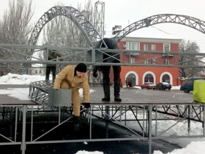 Мобільна сцена, яку встановили на центральній площі міста, отримала загадкові метаморфози із покрівлею і двіччі змінилась напередодні свята
